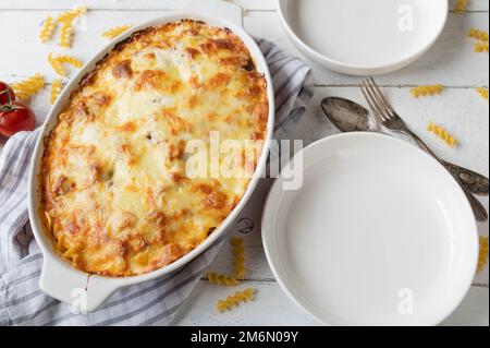 Cocotte de pâtes avec nouilles fusilli, bolognaise et sauce au béchamel. Surmontée d'une croûte de fromage mozzarella sur fond blanc Banque D'Images