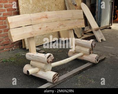 base de banc en bois assemblée à partir de pièces en rondins solides et de pièces de coffre, étape de montage de banc en rondins rustique sans pièce assise Banque D'Images