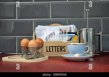 quelques œufs durs dans des tasses en fil de fer sur une planche de bois pour le petit-déjeuner et les lettres postales du matin Banque D'Images