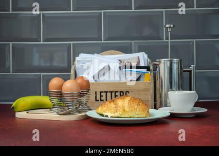 Nous nous concentrons sur le croissant français du petit déjeuner avec une cafetière à œufs durs et une tasse en arrière-plan sur une table rouge Banque D'Images