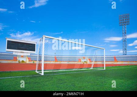 STADE - terrain de football avec but et tapo sur ciel bleu Banque D'Images