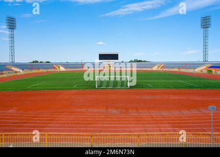 STADE - terrain de football avec but et tapo sur ciel bleu Banque D'Images