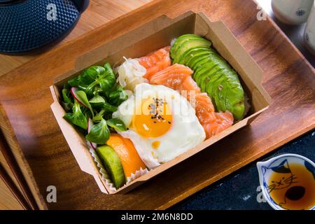 Le saumon du Donburi est servi dans un restaurant japonais à Tokyo. Plat combiné japonais avec poulet, riz, œuf et légumes. Banque D'Images