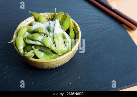 L'edamame est une préparation de soja immature dans la gousse, trouvée dans les cuisines avec des origines en Asie de l'est. Les gousses sont bouillies ou cuites à la vapeur et peuvent être utilisées Banque D'Images