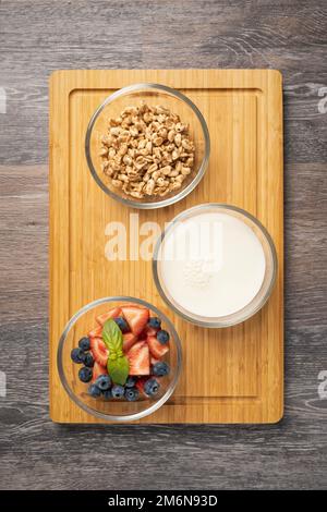 Ingrédients sains pour le petit déjeuner - blé soufflé au lait et aux fruits, fraises, bleuets, aliments sains Banque D'Images