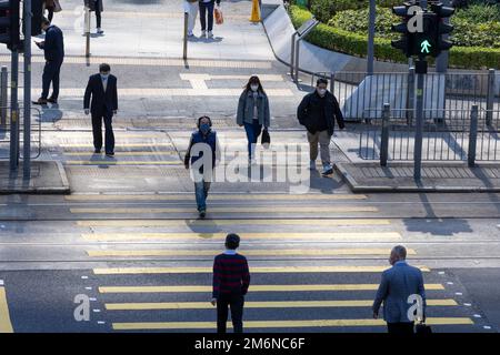2022 décembre 21, Hong Kong.People traversant la rue dans le quartier des affaires à Hong Kong Banque D'Images