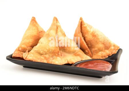 Bouquet de samosa dans une assiette isolée sur fond blanc, célèbre nourriture indienne Banque D'Images