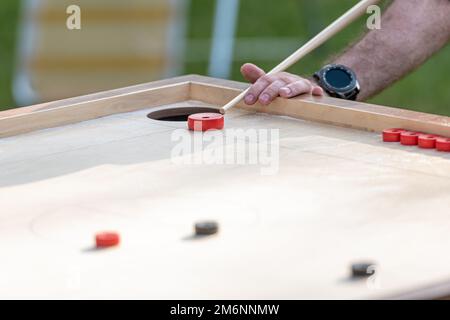 Hommes jouant au jeu de Novus. Novuss est un sport national en Lettonie semblable au billard de poche ou à la piscine. Banque D'Images