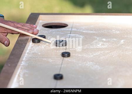 Hommes jouant au jeu de Novus. Novuss est un sport national en Lettonie semblable au billard de poche ou à la piscine. Banque D'Images