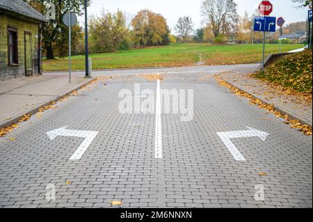 flèches de direction sur la route pavée à l'intersection, choix concept, aller à gauche ou à droite Banque D'Images