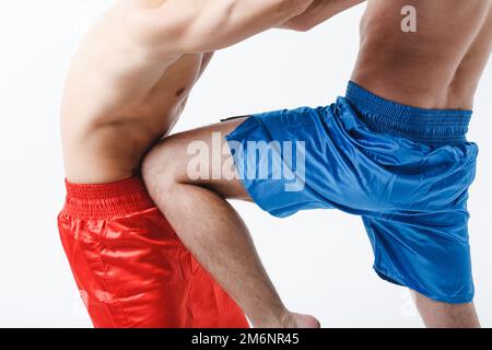 Deux boxeurs hommes combattant muay thai kick boxe genou fond blanc. Banque D'Images