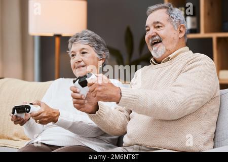 Jeu vidéo, canapé et couple senior avec jeux en ligne à la maison pour des vacances heureux, retraite et style de vie avec la technologie. Enthousiaste, âgé Banque D'Images