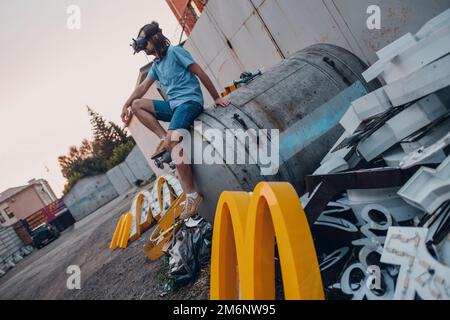 Moscou, Russie - 06.21.2022: McDonald's logo lettre caractère M sur sale tas de déchets vider déchets déchets déchets. Restauration rapide et sa Banque D'Images