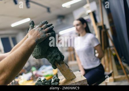 Homme sculpteur crée sculpter buste argile homme sculpture femme. Atelier de création d'artisanat de statue Banque D'Images