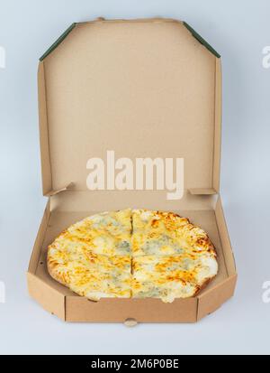 Pizza dans une boîte en carton isolée sur un fond blanc. Vue de dessus de l'emballage de pizza. Des plats délicieux, juteux et savoureux. En-cas rapide. Mauvaise restauration rapide Banque D'Images