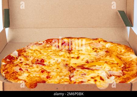 Pizza dans une boîte en carton isolée sur un fond blanc. Vue de dessus de l'emballage de pizza. Des plats délicieux, juteux et savoureux. En-cas rapide. Mauvaise restauration rapide Banque D'Images