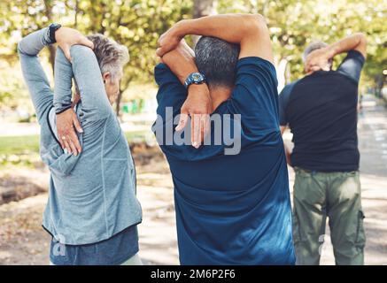 Fitness, nature et personnes âgées faisant des exercices d'étirement avant l'entraînement cardio dans un parc. Santé, bien-être et groupe actif d'amis âgés dans Banque D'Images
