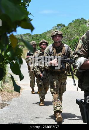 ÉTATS-UNIS Les aviateurs de la Force aérienne qui travaillent à bord de l'escadron 736th des forces de sécurité patrouillent à pied au cours d'un cours d'entraînement au combat à la base aérienne d'Andersen, à Guam (3 mai 2022). Le cours Agile combat Defender a été lancé au début de l'année et a été conçu pour défier les membres des forces de sécurité avec des représentations plus réalistes des environnements déployés par des exercices sur le terrain. Banque D'Images