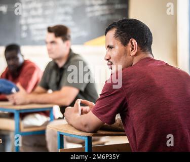 Un interprète traduit une discussion entre Ahmed Alasa, le chef de village de Gofat est, et l'équipe des affaires civiles du Groupe expéditionnaire aérien de 409th, à l'intérieur de la maison scolaire de Gofat est, concernant l'impact positif d'un accès accru à l'eau, Agadez, Niger, 3 mai 2022. Le Niger est un partenaire vital des États-Unis AFRICOM, ÉTATS-UNIS Air Forces Africa, et l'AEG de 409th pour le maintien des opérations de maintien de la paix, l'aide humanitaire étrangère, le contrôle des maladies infectieuses et le renforcement des capacités des partenaires. Les relations établies au cours de ces événements offrent la possibilité d'un engagement et d'un partenariat accrus Banque D'Images