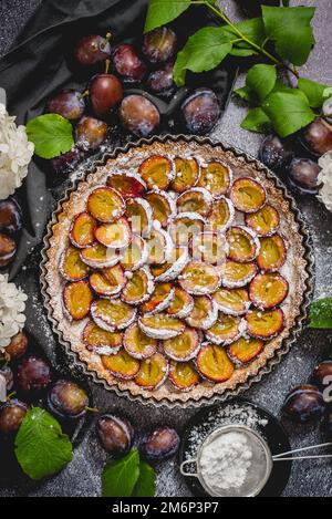 Délicieuse tarte aux prunes maison avec sucre en poudre et fruits frais Banque D'Images