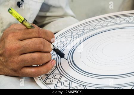 Artisans peignant et décorant des produits céramiques dans une usine de poterie à Fès, au Maroc, en Afrique du Nord Banque D'Images