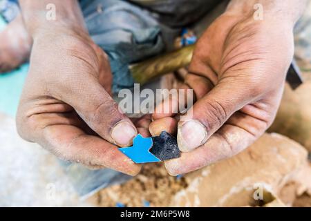 Artisan montrant à la main fait de minuscules carreaux de céramique qui s'adaptent parfaitement les uns aux autres dans l'usine de poterie à Fès, Maroc, Afrique du Nord Banque D'Images