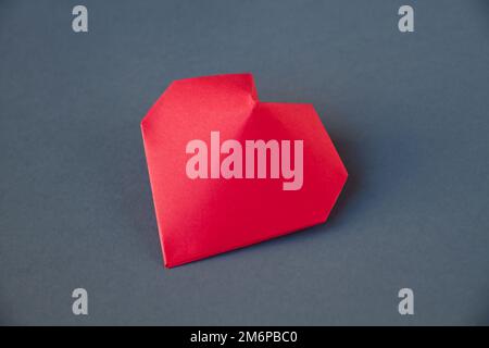 Cœur en papier rouge origami isolé sur fond gris Banque D'Images