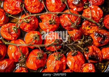 Gros plan de tomates cerises rouges rôties à l'ail, aux herbes et à l'olive Banque D'Images