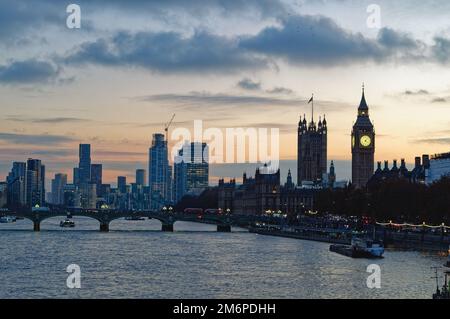 Le Parlement et les gratte-ciel de l'autre côté de la Tamise à la tombée de la nuit lors d'une soirée hivernale Angleterre Royaume-Uni Banque D'Images