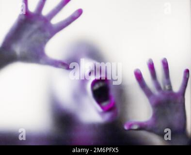 Image effrayante des mains derrière le verre, femme fantôme d'horreur derrière la porte, concept d'Halloween Banque D'Images