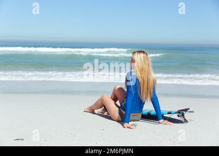 Femme caucasienne pendant la session de surf à la plage Banque D'Images