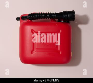 Cartouche en plastique rouge pour carburants liquides et lubrifiants sur fond beige, vue de dessus Banque D'Images