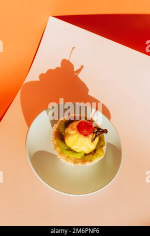 Délicieux petits gâteaux décorés de baies fraîches sur fond coloré Banque D'Images