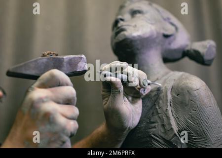 Le sculpteur d'homme crée une sculpture de femme humaine en buste sculptés. Atelier de création d'artisanat de statue Banque D'Images