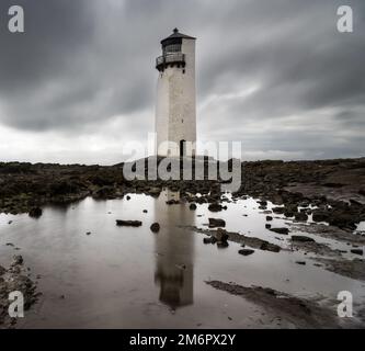 Le phare historique de la Southerness en Écosse avec des reflets dans les bassins de marée en premier plan Banque D'Images