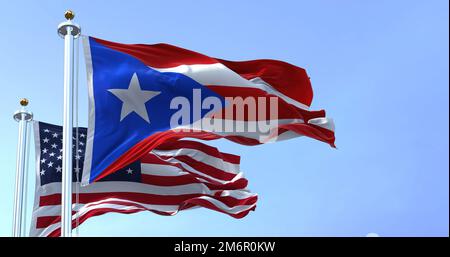 Drapeau de Porto Rico agitant dans le vent avec le drapeau des États-Unis un jour clair Banque D'Images
