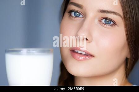 Bonne jeune femme avec un verre de lait ou de lait de protéine shake, boisson de cocktail saine pour l'alimentation et le bien-être Banque D'Images