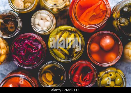 Conservation des légumes dans des pots en verre. Tomates, concombres, champignons, chou, poivre Banque D'Images