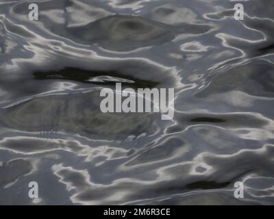 La texture de l'eau avec la lumière du soleil reflétant l'apparence du métal liquide Banque D'Images