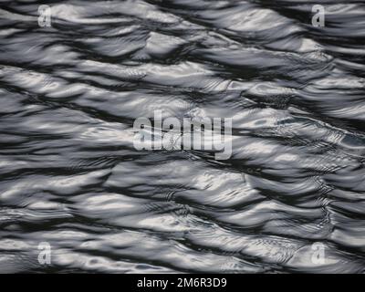 La texture de l'eau avec la lumière du soleil reflétant l'apparence du métal liquide Banque D'Images