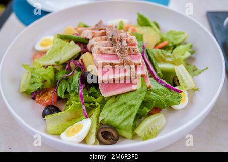 Salade de thon sur une assiette avec avacado et œuf d'oiseau Banque D'Images