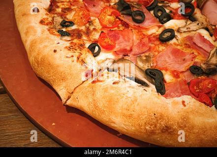 Pizza capriciosa avec croûte farcie au fromage dans la pizzeria, nourriture Banque D'Images