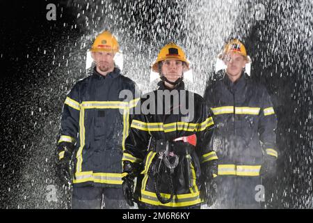 Portrait d'un groupe de pompiers debout et marchant courageux et optimiste avec une femme comme chef d'équipe. Banque D'Images