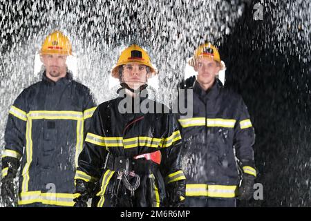 Portrait d'un groupe de pompiers debout et marchant courageux et optimiste avec une femme comme chef d'équipe. Banque D'Images