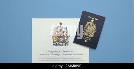 Un passeport canadien sur un certificat de citoyenneté canadienne sur fond bleu clair Banque D'Images