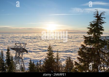 Vue panoramique sur la télécabine Skyride au sommet de Vancouver, au-dessus des White Puffy Clouds, au coucher du soleil Banque D'Images