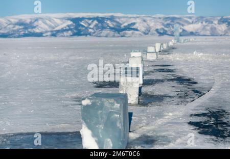 Morceaux de glace couchés sur la glace lisse idéale de baikal avec des hummocks de glace à l'horizon Banque D'Images