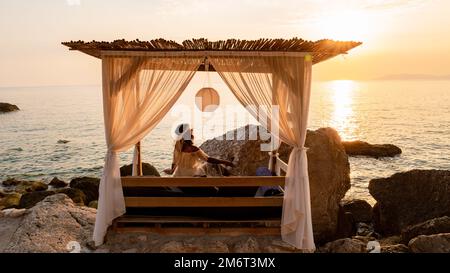 Lits de plage avec parasols blancs donnant sur l'océan en Turquie Banque D'Images