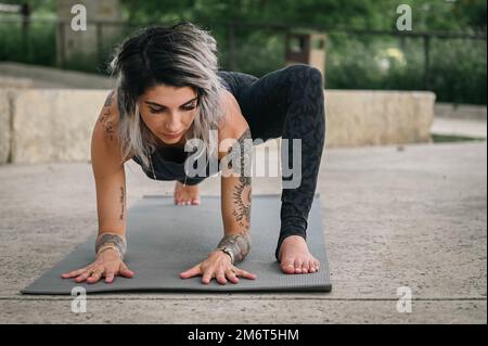 Melissa Aguirre, entraîneure de vie holistique et spécialiste de la gestion du stress, s'étire dans une pose de yoga dans le parc de la liberté sur le centre médical de l'armée de Brooke, San Antonio, Texas, 4 mai 2022. Aguirre utilise sa connexion en tant que conjoint militaire et sa certification en tant qu'instructeur de yoga pour servir les soldats de l'armée américaine souffrant de traumatismes cérébraux, de traumatismes liés au stress et de problèmes de bien-être mental. Banque D'Images