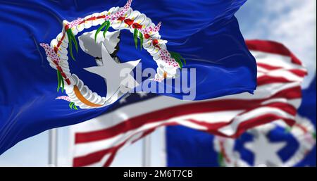 Drapeaux des îles Mariannes du Nord agitant dans le vent avec le drapeau américain par temps clair Banque D'Images